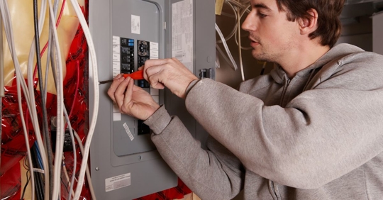 man adjusting electrical panel
